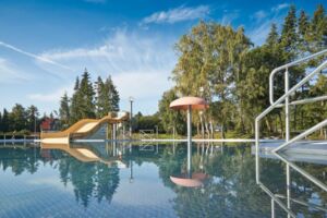 Fotografische Darstellung vom Freibad Dingelstädt. Zu sehen ist das Nichtschwimmerbecken mit einer Rutsche, einem Wasserspiel und der Einstiegstreppe.